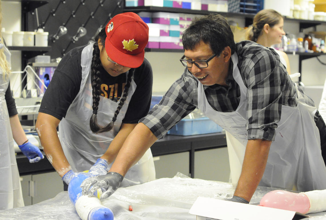 Dr. Lindsay Crowshoe, MD, associate professor in the Department of Family Medicine at the Cumming School of Medicine, shows a camper how to cast a broken arm, by demonstrating the technique on a balloon. Crowshoe is one of many faculty throughout UCalgary who spent the week introducing Indigenous students to careers in medicine, engineering, veterinary medicine, science and arts, just to name a few.